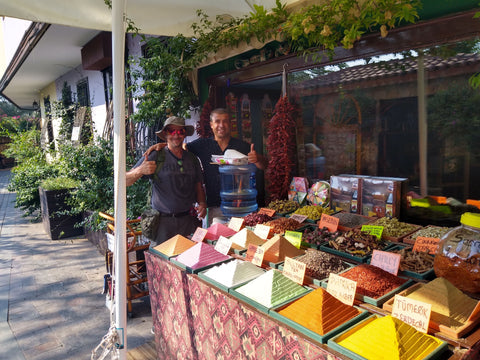 Two men standing behind a market stall