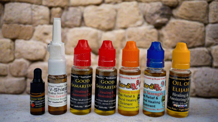 Collection of various essential oil bottles with colorful caps on a stone surface.