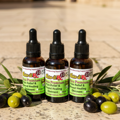 Three bottles of Ultra Premium Pain Relief & Wound Healing Ointment with olive leaves on a stone surface.