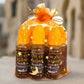 Six bottles of 'Oil of Elijah' on a decorative stand with a blurred architectural background.