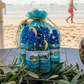 6 Bottles of Kure it Bible healing oil on a table with a beach in the background
