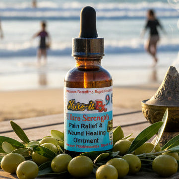 Bottle of Rx9 oil with olive leaves on a wooden table at the beach